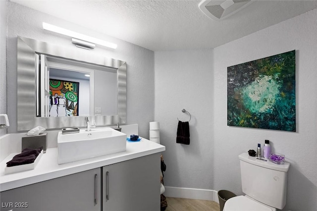 5125 Turnberry Ln, Las Vegas, NV 89113 - bathroom featuring toilet, vanity, a textured ceiling, wood finished floors, and baseboards