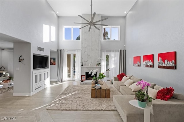 5125 Turnberry Ln, Las Vegas, NV 89113 - living area with ceiling fan, a fireplace with raised hearth, plenty of natural light, a high ceiling, and wood finished floors