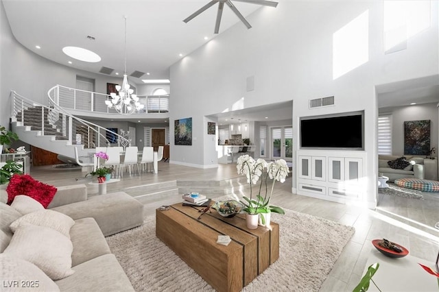 5125 Turnberry Ln, Las Vegas, NV 89113 - living area featuring a chandelier, a high ceiling, stairs, a ceiling fan, and wood finished floors