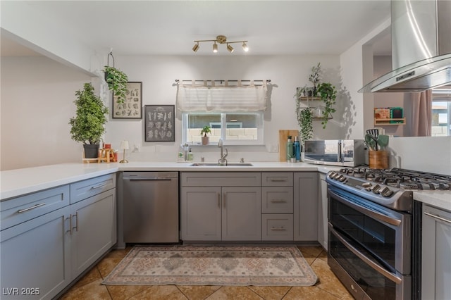508 Purcell Dr, Las Vegas, NV 89107 - kitchen featuring appliances with stainless steel finishes, a sink, wall chimney range hood, gray cabinets, and light tile patterned floors