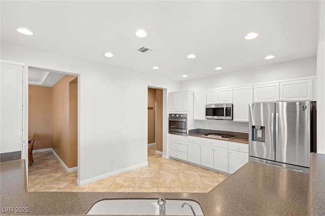 2069 Colvin Run Dr, Henderson, NV 89052 - kitchen with appliances with stainless steel finishes, dark countertops, recessed lighting, white cabinetry, and a sink