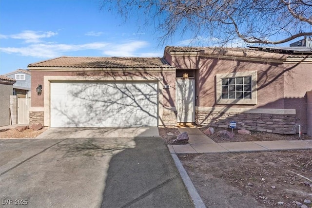 5184 Mineral Lake Dr, Las Vegas, NV 89122 - view of front of home featuring stone siding, stucco siding, asphalt driveway, an attached garage, and a tile roof