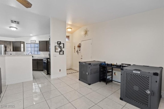 5184 Mineral Lake Dr, Las Vegas, NV 89122 - kitchen with stainless steel range oven, light tile patterned floors, baseboards, and refrigerator