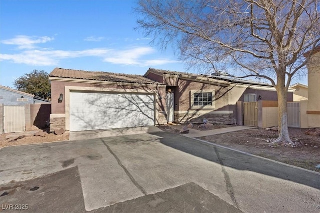 5184 Mineral Lake Dr, Las Vegas, NV 89122 - view of front of house with an attached garage, driveway, a gate, and stone siding