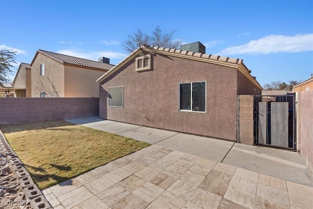 5184 Mineral Lake Dr, Las Vegas, NV 89122 - rear view of house featuring stucco siding, a patio area, a gate, and a tiled roof
