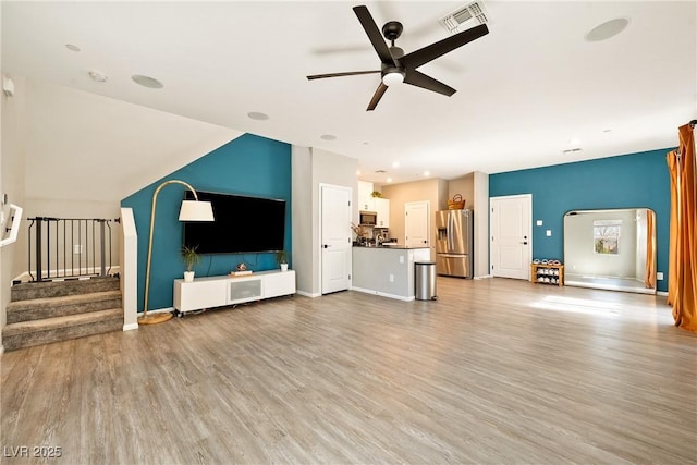 1023 Brilliant Meadow Ave, North Las Vegas, NV 89086 - unfurnished living room with a ceiling fan, light wood-style floors, stairs, and baseboards