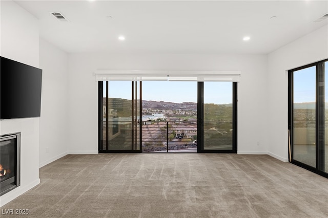 350 Solitude Peak Ln, Henderson, NV 89012 - unfurnished living room with carpet floors, baseboards, a glass covered fireplace, and recessed lighting