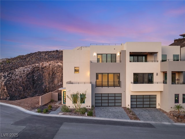 350 Solitude Peak Ln, Henderson, NV 89012 - view of front of property featuring stucco siding, an attached garage, decorative driveway, and a mountain view
