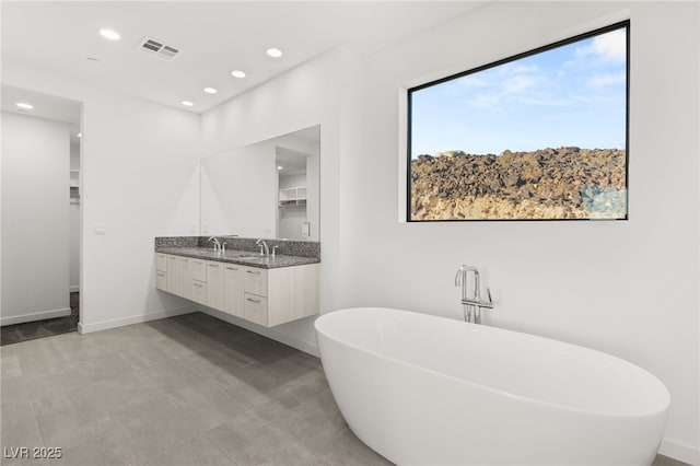 350 Solitude Peak Ln, Henderson, NV 89012 - full bathroom with double vanity, a freestanding tub, baseboards, and recessed lighting
