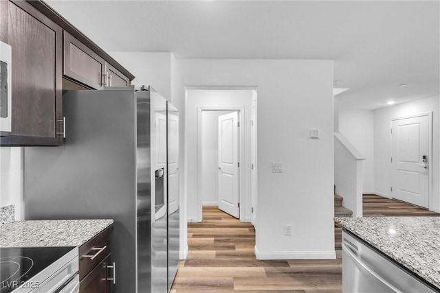 2846 Cerulean Stars Ln Unit 1, Las Vegas, NV 89183 - kitchen with light wood-type flooring, dark brown cabinetry, light stone counters, baseboards, and appliances with stainless steel finishes