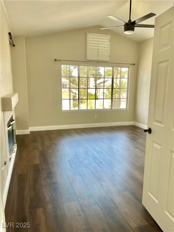 8397 San Ramon Dr, Las Vegas, NV 89147 - unfurnished living room featuring a ceiling fan, plenty of natural light, dark wood-style floors, vaulted ceiling, and baseboards
