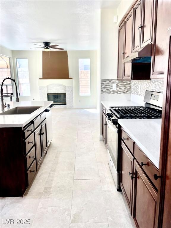 8397 San Ramon Dr, Las Vegas, NV 89147 - kitchen featuring gas range oven, a sink, under cabinet range hood, a ceiling fan, and light countertops