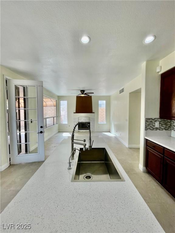 8397 San Ramon Dr, Las Vegas, NV 89147 - kitchen featuring open floor plan, a high end fireplace, ceiling fan, baseboards, and a sink