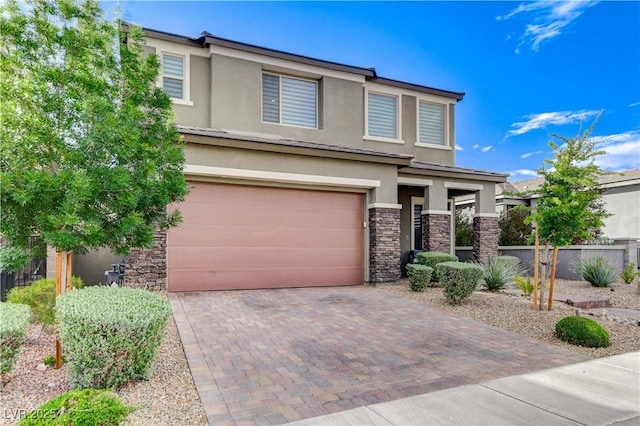 view of front of home featuring stone siding, stucco siding, an attached garage, and decorative driveway