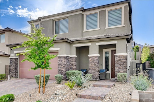 view of front facade featuring stone siding, stucco siding, decorative driveway, and a garage