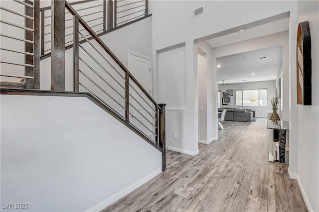 staircase featuring wood finished floors, recessed lighting, and baseboards