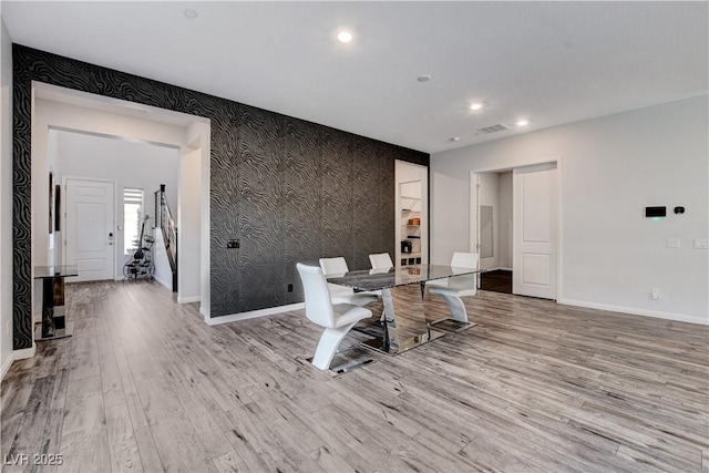office featuring baseboards, wood finished floors, wallpapered walls, recessed lighting, and an accent wall