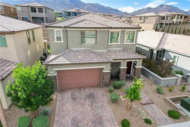 view of front facade with stucco siding, stone siding, a residential view, and a mountain view