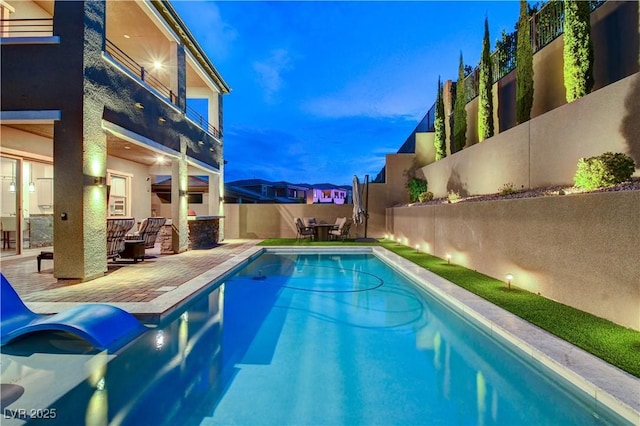 view of swimming pool with a patio and fence