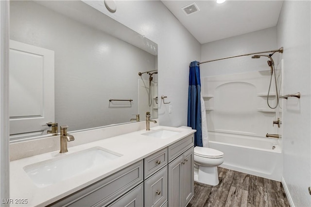 bathroom with wood finished floors, toilet, shower / tub combo with curtain, and double vanity