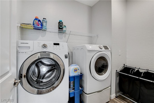 laundry room featuring independent washer and dryer and wood finished floors