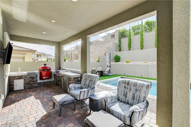 view of patio featuring an outdoor kitchen, a fenced backyard, and grilling area
