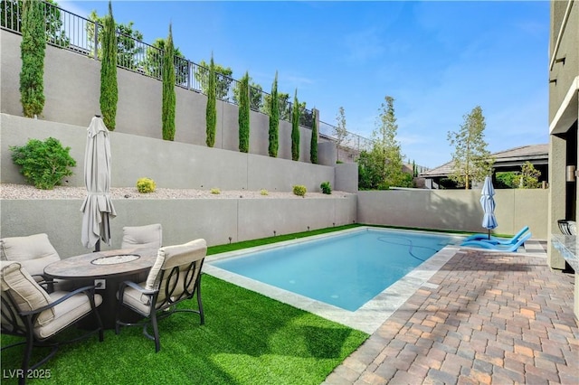 view of swimming pool featuring a fenced backyard and a patio