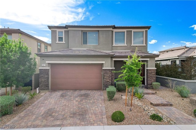 traditional home featuring stone siding, stucco siding, an attached garage, decorative driveway, and fence