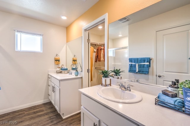 6521 Cinnamon Hazelnut St Lot 91, North Las Vegas, NV 89084 - full bathroom with wood finished floors, a shower stall, two vanities, a walk in closet, and baseboards
