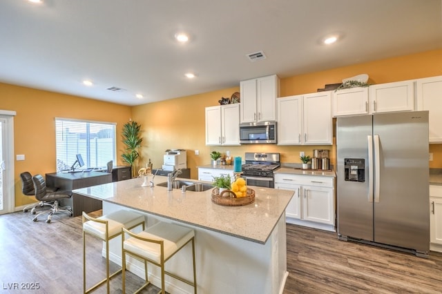 6521 Cinnamon Hazelnut St Lot 91, North Las Vegas, NV 89084 - kitchen with appliances with stainless steel finishes, a sink, white cabinetry, dark wood finished floors, and light stone countertops