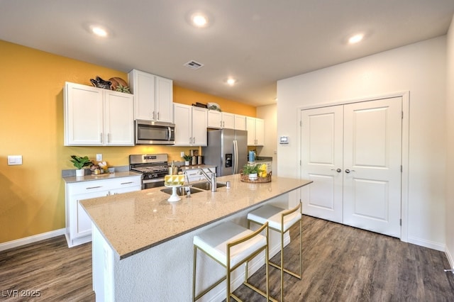6521 Cinnamon Hazelnut St Lot 91, North Las Vegas, NV 89084 - kitchen featuring stainless steel appliances, a sink, white cabinetry, dark wood-style floors, and baseboards