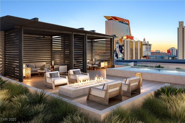 700 W Carson Ave Unit 2307, Las Vegas, NV 89106 - patio terrace at dusk with an outdoor living space with a fire pit, a ceiling fan, and a view of city