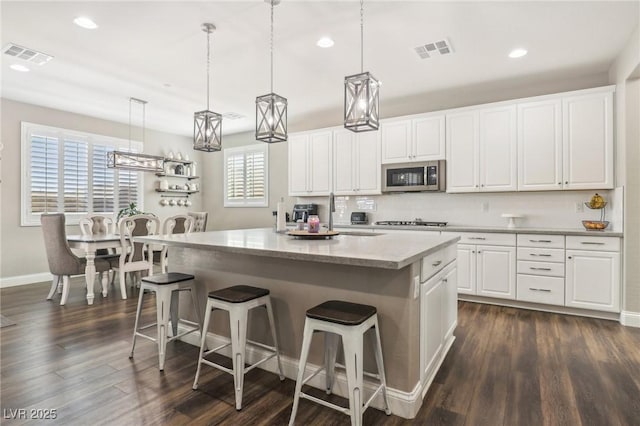 716 Cadence View Way, Henderson, NV 89011 - kitchen featuring stainless steel appliances, a center island, white cabinets, a sink, and a breakfast bar