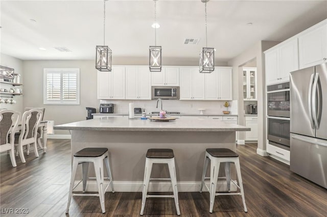 716 Cadence View Way, Henderson, NV 89011 - kitchen featuring stainless steel appliances, dark wood-style flooring, white cabinets, and a kitchen bar