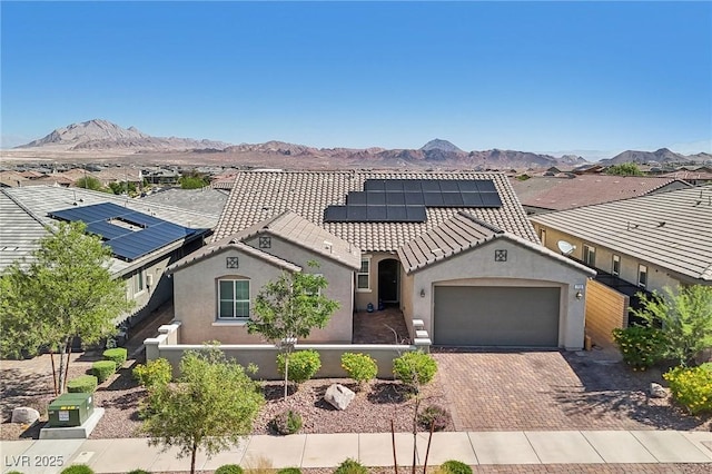 716 Cadence View Way, Henderson, NV 89011 - mediterranean / spanish-style home with a garage, stucco siding, decorative driveway, a mountain view, and roof mounted solar panels
