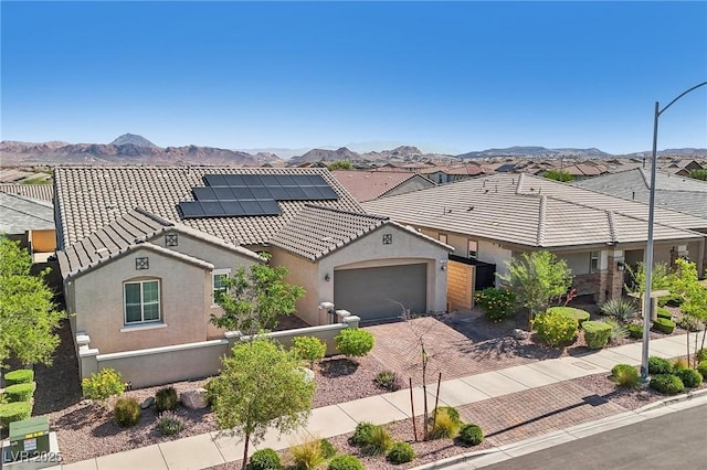 716 Cadence View Way, Henderson, NV 89011 - view of front of property with roof mounted solar panels, driveway, a garage, stucco siding, and a mountain view
