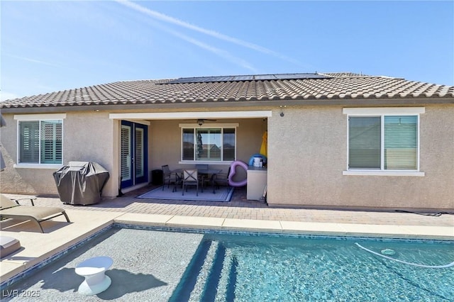 716 Cadence View Way, Henderson, NV 89011 - back of house featuring stucco siding, solar panels, and an outdoor pool