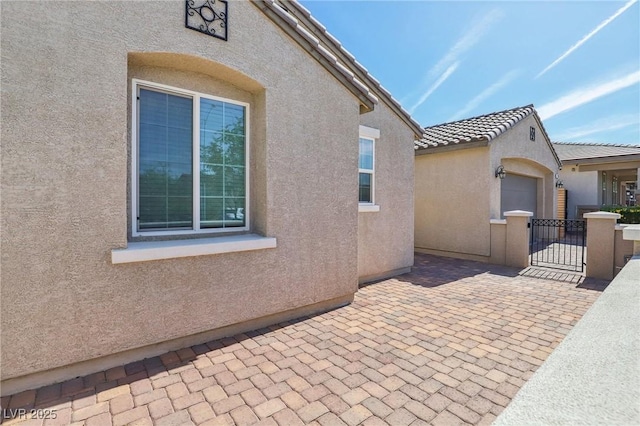 716 Cadence View Way, Henderson, NV 89011 - view of home's exterior featuring stucco siding, a gate, and a patio