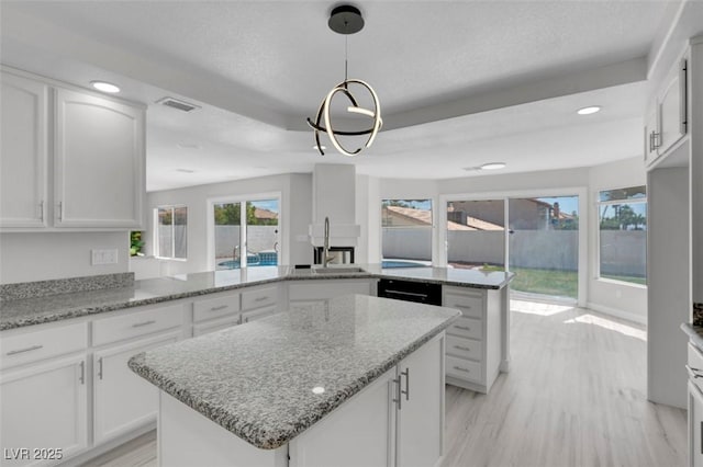 3604 N Campbell Rd, Las Vegas, NV 89129 - kitchen featuring a center island, white cabinetry, light wood finished floors, and recessed lighting