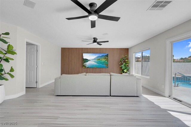 3604 N Campbell Rd, Las Vegas, NV 89129 - unfurnished living room with light wood-type flooring, baseboards, ceiling fan, wood walls, and an accent wall
