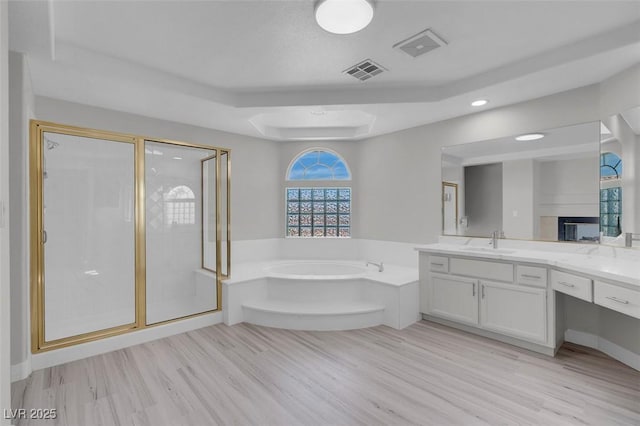 3604 N Campbell Rd, Las Vegas, NV 89129 - full bathroom with a garden tub, a raised ceiling, vanity, a stall shower, and wood finished floors
