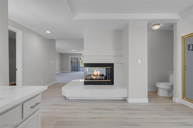 3604 N Campbell Rd, Las Vegas, NV 89129 - living room with a multi sided fireplace, baseboards, light wood finished floors, and recessed lighting