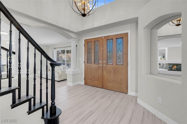 3604 N Campbell Rd, Las Vegas, NV 89129 - foyer entrance with arched walkways, wood finished floors, a chandelier, stairway, and a high ceiling