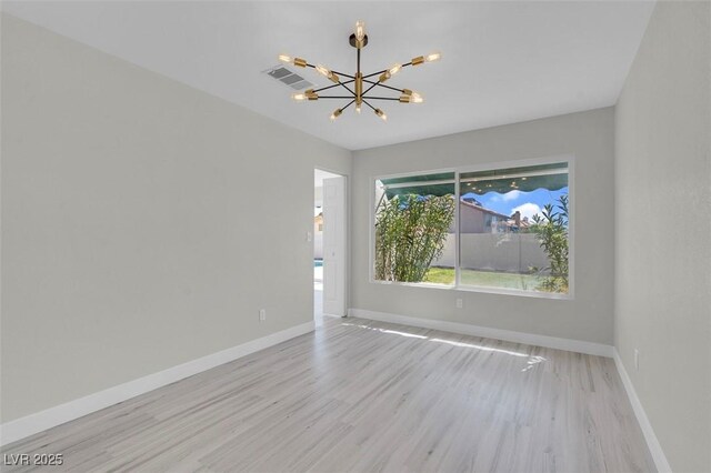 3604 N Campbell Rd, Las Vegas, NV 89129 - empty room featuring a chandelier, light wood-style floors, and baseboards