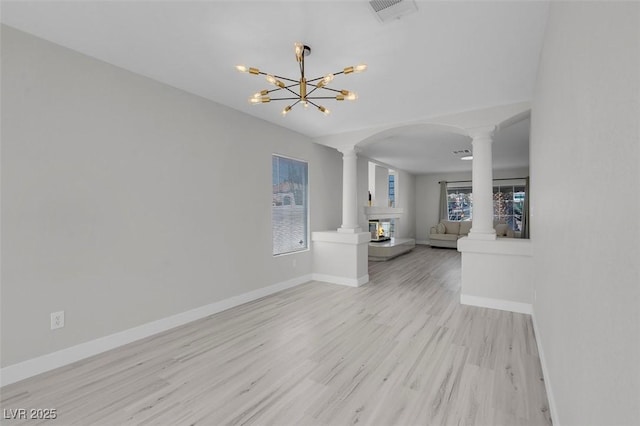 3604 N Campbell Rd, Las Vegas, NV 89129 - unfurnished living room with ornate columns, a chandelier, wood finished floors, baseboards, and arched walkways