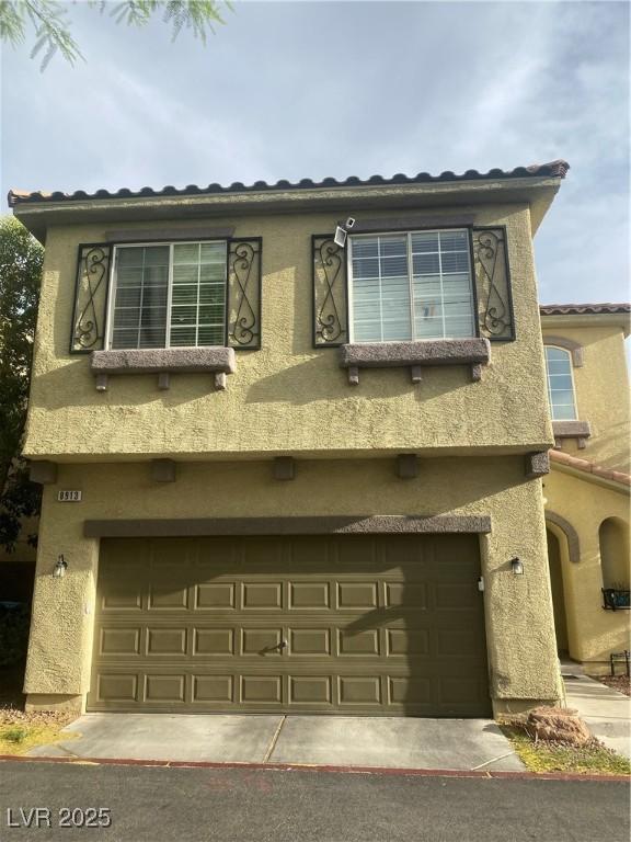 8913 Cambridge Glen Ct, Las Vegas, NV 89149 - view of front of home with an attached garage, stucco siding, and a tiled roof