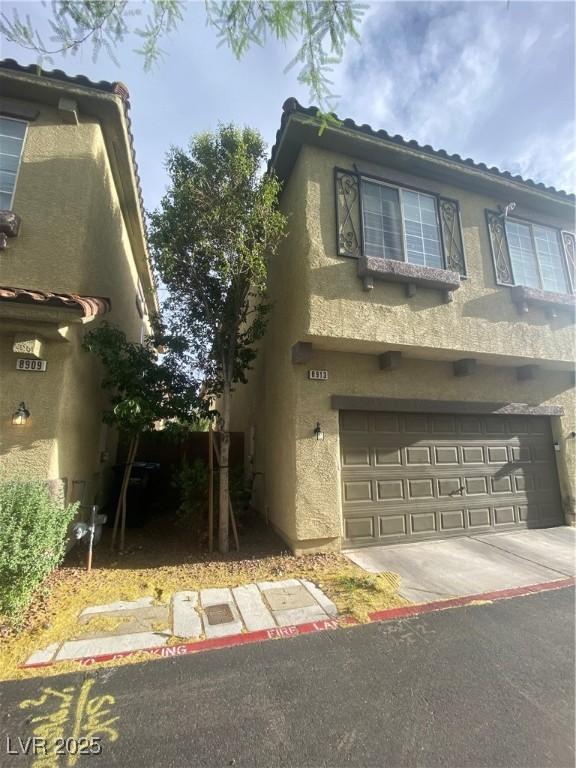 8913 Cambridge Glen Ct, Las Vegas, NV 89149 - view of front of house with stucco siding, an attached garage, concrete driveway, and a tile roof