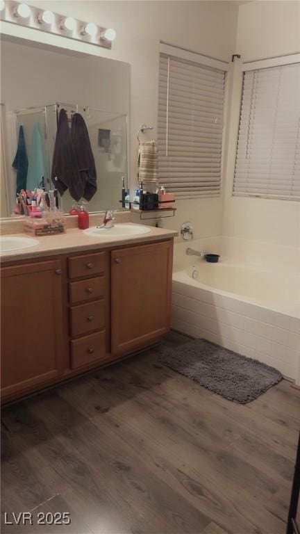 8913 Cambridge Glen Ct, Las Vegas, NV 89149 - bathroom with wood finished floors, a bath, double vanity, and a stall shower
