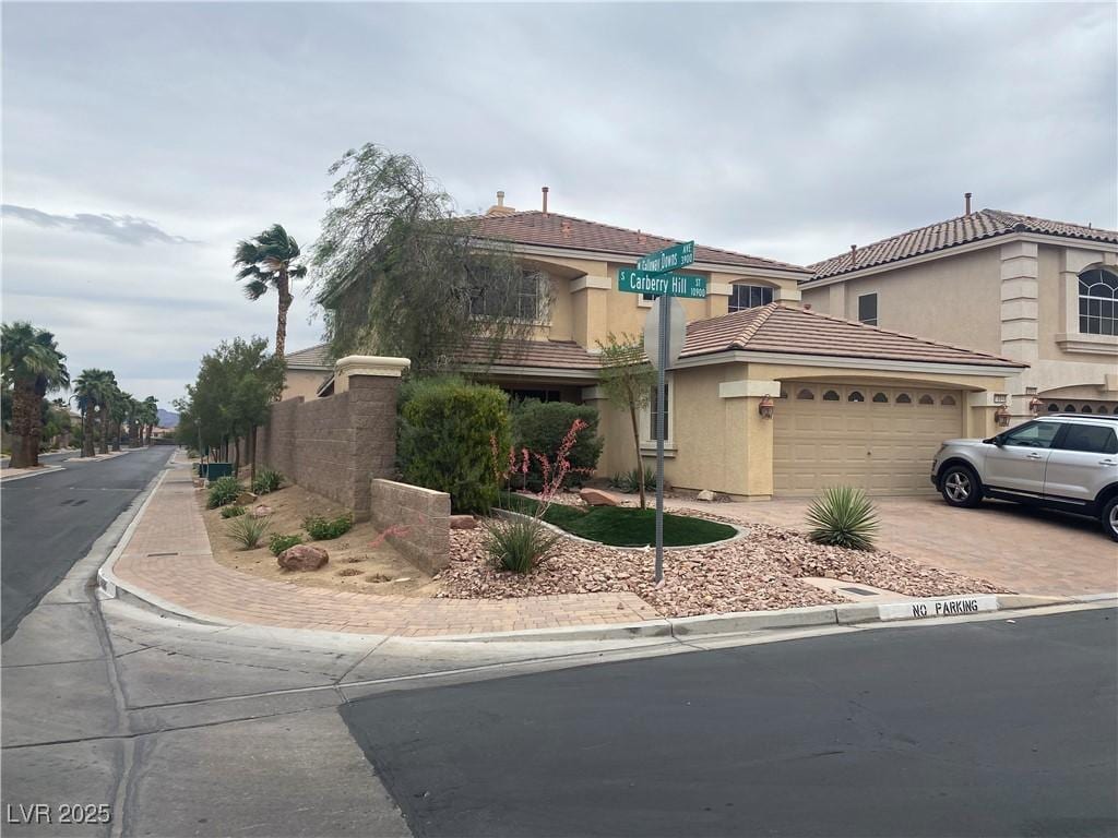 10948 Carberry Hill St, Las Vegas, NV 89141 - view of front of house featuring driveway, an attached garage, stucco siding, and a tiled roof
