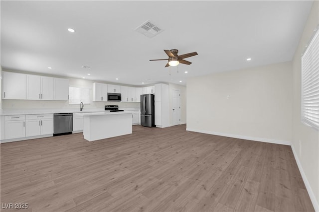 952 Balzar Ave, Las Vegas, NV 89106 - kitchen featuring stainless steel appliances, open floor plan, light wood finished floors, a ceiling fan, and light countertops